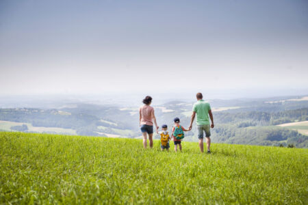 Familie, wandert auf einem Hochplateau mit Blick über das Tal. Ort: 5 Hochneukirchen Rundwanderweg Hutwisch
